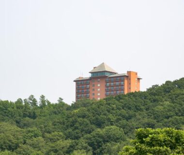Large hotel building perched above dense forest at Tokachi Makubetsu Onsen Grandvrio Hotel in Hokkaidō