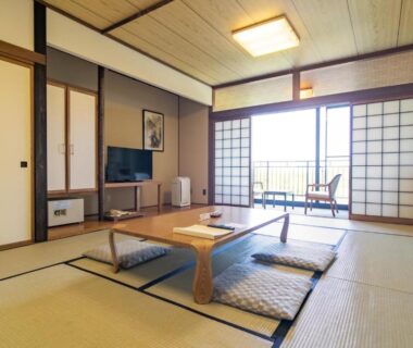 Tatami room with low table, floor cushions, shoji doors and balcony seating at Tokachi Makubetsu Onsen, Hokkaidō