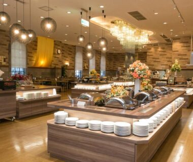 Buffet serving stations with plates and chandeliers at Tokachi Makubetsu Onsen Grandvrio Hotel, Hokkaidō