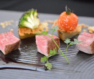 Seared beef cubes with garnishes on black plate at Tokachigawa Moor Onsen Seijyakubow Hokkaidō