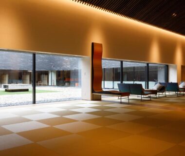 Reception lobby with tatami-style flooring, low lounge chairs and long windows overlooking courtyard at Tokachigawa Moor Onsen Seijyakubow, Hokkaidō