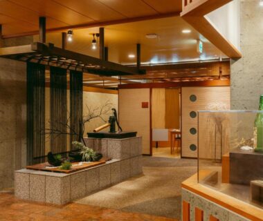 Spacious Tokigasane lobby with stone basin, wooden beams and display case in Ishikawa, Chūbu, Japan