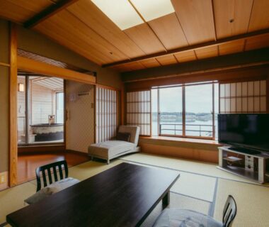 Traditional tatami room with low table, zaisu chairs, shoji screens and TV at Tokigasane in Ishikawa