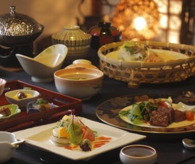 Traditional multi-course Japanese meal arranged on lacquer trays and plates in a ryokan dining setting