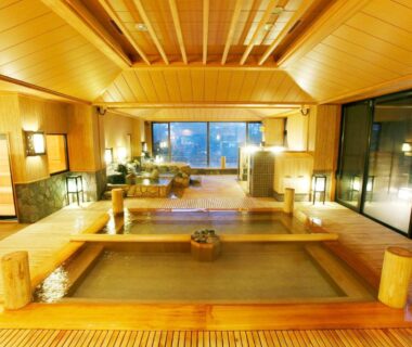 Communal wooden onsen baths with warm lighting and large windows at Tokinoniwa, Gunma, Kantō