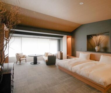 Twin beds on low wooden platforms with seating area and minimalist Japanese decor, Tokiwa Hotel Yamanashi Chūbu