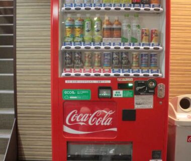 Red Coca-Cola vending machine in Tokiwa Ryokan hallway, Tochigi, stocked with canned and bottled drinks