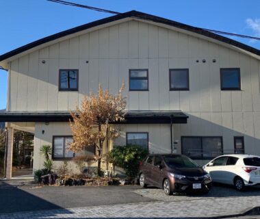Two-story ryokan facade with parked cars at Tokiwa Ryokan in Tochigi, Kantō, Japan