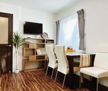 Bright dining table with chairs and TV at Louis House, Tokyo