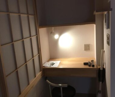 Compact wooden desk and chair by shoji screen with wall lamp at Tokyo inn Sakura An, Tokyo