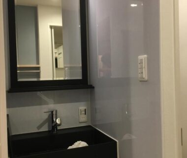 Black rectangular sink and mirror in compact bathroom at Tokyo inn Sakura An, Tokyo