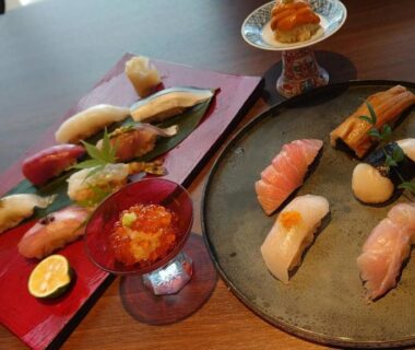 Assorted nigiri sushi on lacquer and ceramic plates with citrus garnish and small roe cup at Toriizaki Club, Chiba Kantō