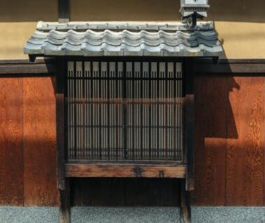 Wooden lattice window and tiled roof at Toshiharu Ryokan in Kyoto