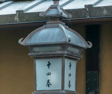 Hanging metal lantern with kanji at Toshiharu Ryokan in Kyoto