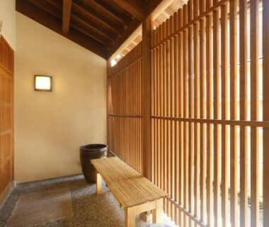 Interior corridor with wooden lattice screens and bench at Towa Ryokan in Kyoto