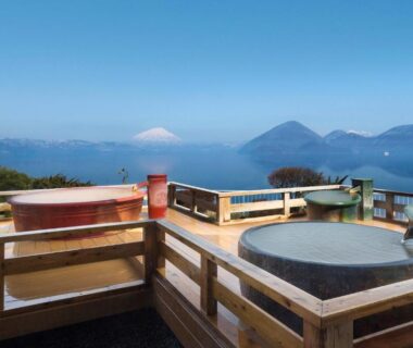Round outdoor baths on wooden deck overlooking lake and mountains at Toya Kohan Tei, Hokkaido