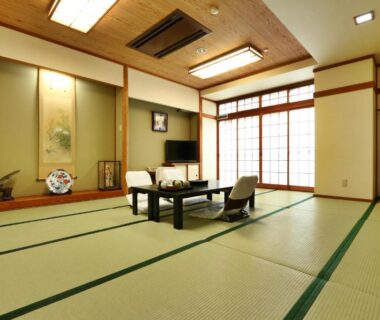 Traditional tatami room with low table, floor chairs, shoji screens and tokonoma at Toyofuku Ryokan in Hyōgo