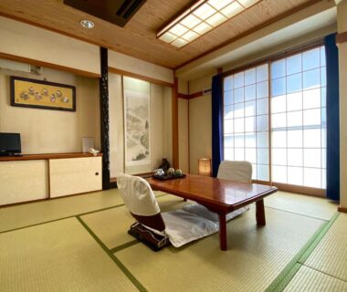 Traditional tatami room with low table, zabuton chairs and shoji screens at Toyofuku in Hyōgo, Kansai