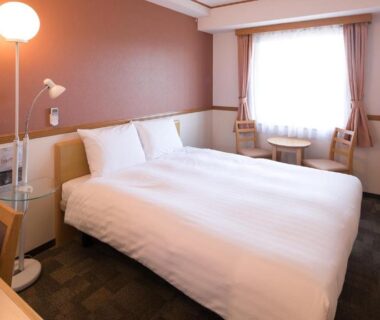 Simple double room with bed, desk, lamp and window at Toyoko Inn Maebashi Ekimae in Gunma