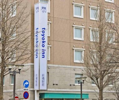 Street view of Toyoko Inn Maebashi Ekimae exterior with signage and bare trees in urban Gunma setting