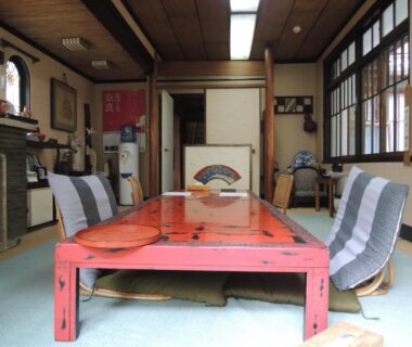 Low red lacquer table with zaisu chairs on tatami mats in a ryokan room at Tsubakiso, Nara