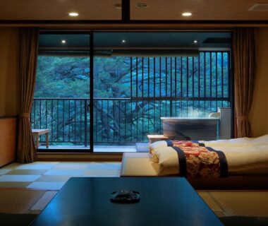 Tatami seating area, low table, twin beds, balcony with wooden soaking tub and garden view at Tsuganoki, Tochigi