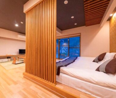 Low bed with wooden slatted divider and seating area at Tsukasa Ryokan, Saga, Kyūshū, Japan