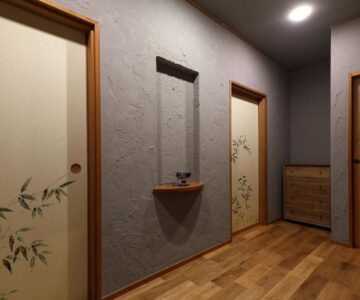 Wooden floored corridor with decorative sliding fusuma doors and small wall shelf at a ryokan in Yamagata