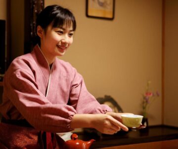 Woman in kimono serving tea in tatami room at Tsukasaya Ryokan, Yamagata, Tōhoku