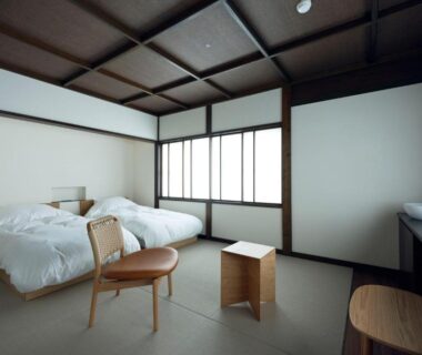 Minimal tatami room with two beds, shoji screens, low wooden furniture and sink