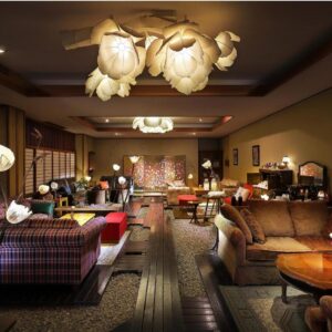 Warm-lit lounge with sofas, shoji screens and decorative lanterns at Tsukinoike in Yamagata Tōhoku