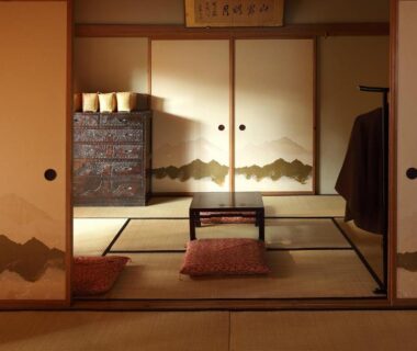Tatami room with low table, zabuton cushions and painted fusuma sliding doors at Tsuruya Ryokan in Nagano