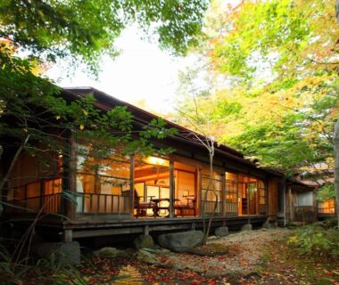 Wooden ryokan veranda with shoji-lit interior and surrounding trees in Nagano Chūbu
