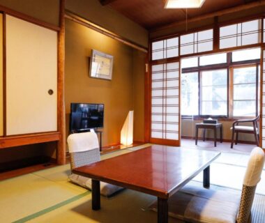 Traditional tatami room with low wooden table, zaisu chairs, shoji screens and window seating at Tsuruya Ryokan in Hyōgo