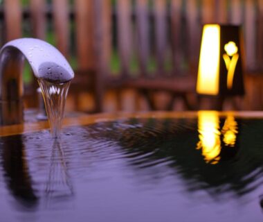 Flowing onsen bath spout with lantern and wooden surrounds at Tsutaya Tokinoyado Kazari in Nagano