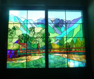Stained glass window depicting mountains and trees at Tsuyukusa ryokan in Gifu