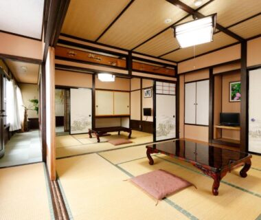 Spacious tatami room with low table, zabuton cushion, shoji screens and sliding fusuma at Tsuyukusa, Gifu