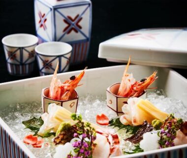 Assorted seafood and garnishes on ice with ceramic sake set in ryokan dining