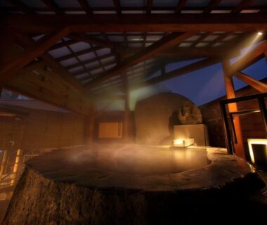 Steaming circular wooden bath with exposed beams and warm lantern lighting inside Uesugi no Miyu Yamagata