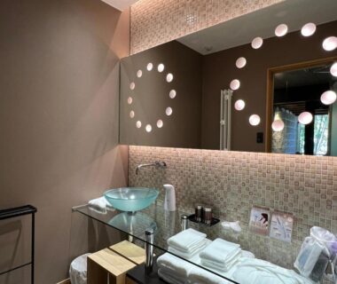 Glass vessel sink and illuminated circular mirror in Ufufu bathroom, Shizuoka, Chūbu Japan