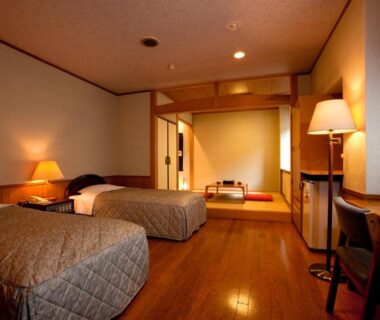 Spacious twin room with Western beds and tatami seating, sliding screens and wooden floor at Ukiha Ōita