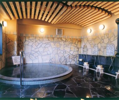 Circular indoor onsen tub with shower stations, Ukiha ryokan, Ōita, Kyūshū, Japan