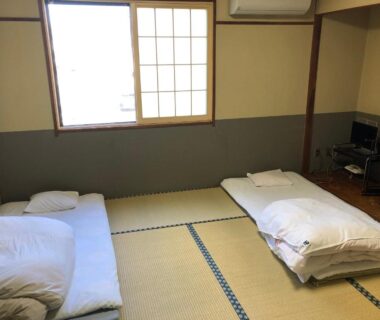 Traditional tatami room with two futons and shoji window at Umeoka Ryokan, Nagano