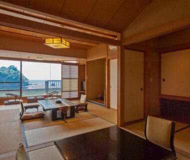Tatami room with low table, shoji screens and balcony overlooking the sea in Shizuoka