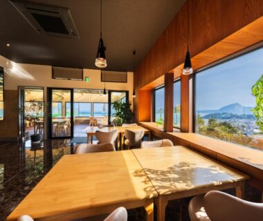 Dining area with wooden tables and panoramic windows at Umine Annex, Ōita, Kyūshū
