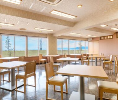 Dining area with wooden tables and chairs and ocean view at Umino Hotel Hajime in Oita
