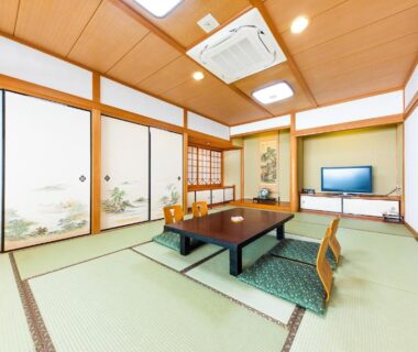 Tatami room with low table, floor chairs and shoji screens at Umino Hotel Hajime in Oita