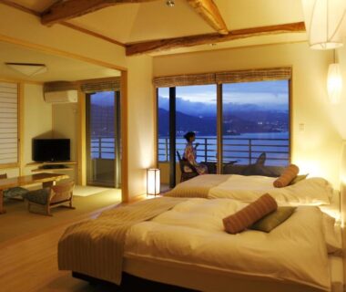 Twin beds, tatami seating, shoji screens, window overlooking water at Uminohana, Shizuoka, Chūbu Japan