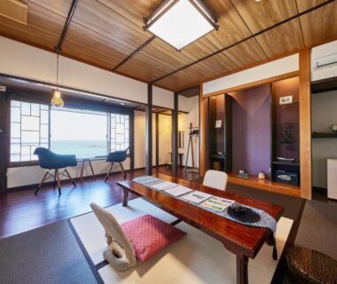 Bright tatami room with low wooden table, zabuton cushions and window seating at Uminone in Hyōgo