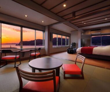 Tatami room with low table and bed overlooking coastal sunset at Uminoniwa, Chiba